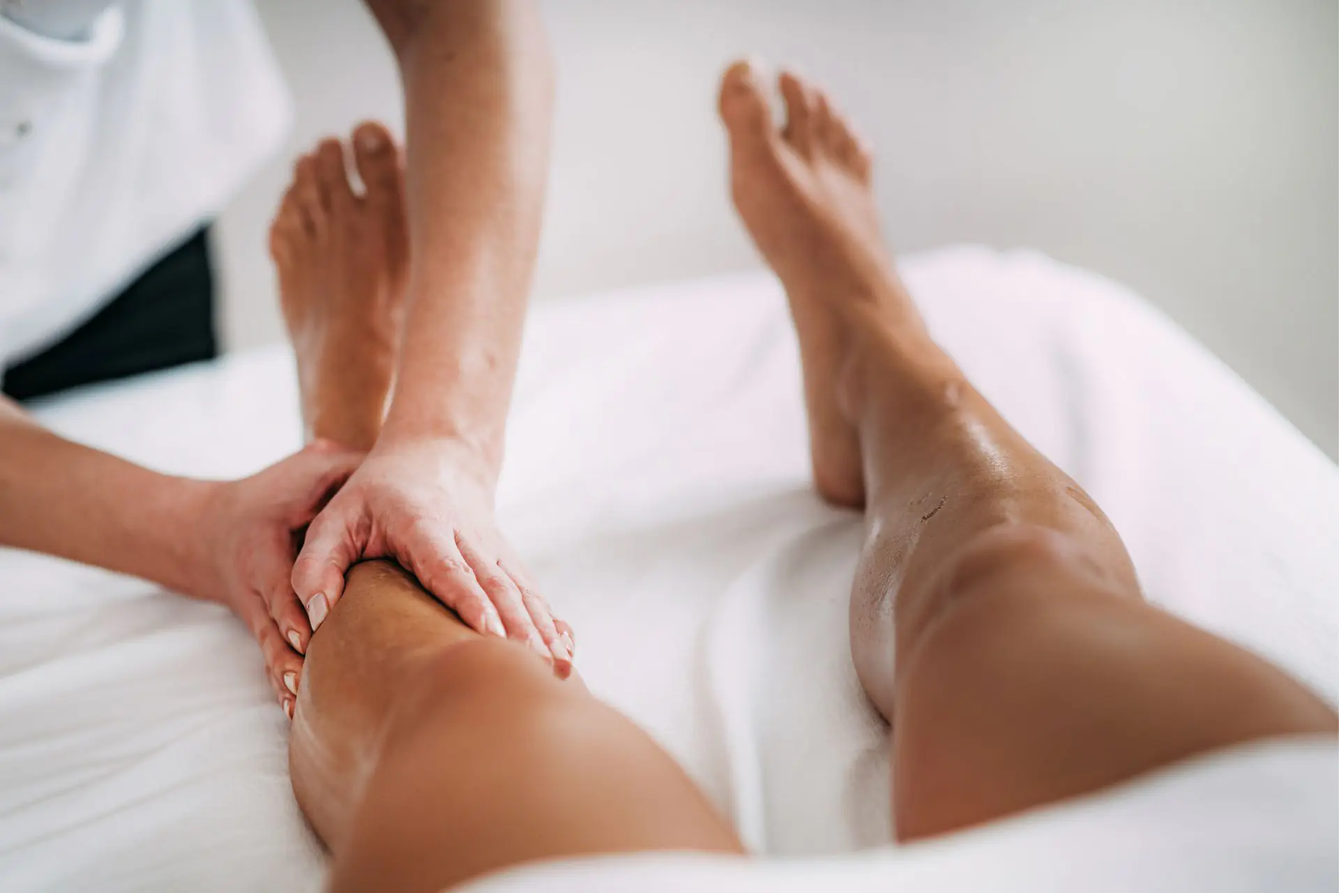 Mains de professionnelle en train de réaliser un massage des jambes